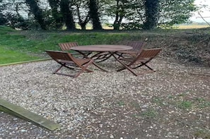 Ein runder Holztisch mit vier Stühlen im Freien.