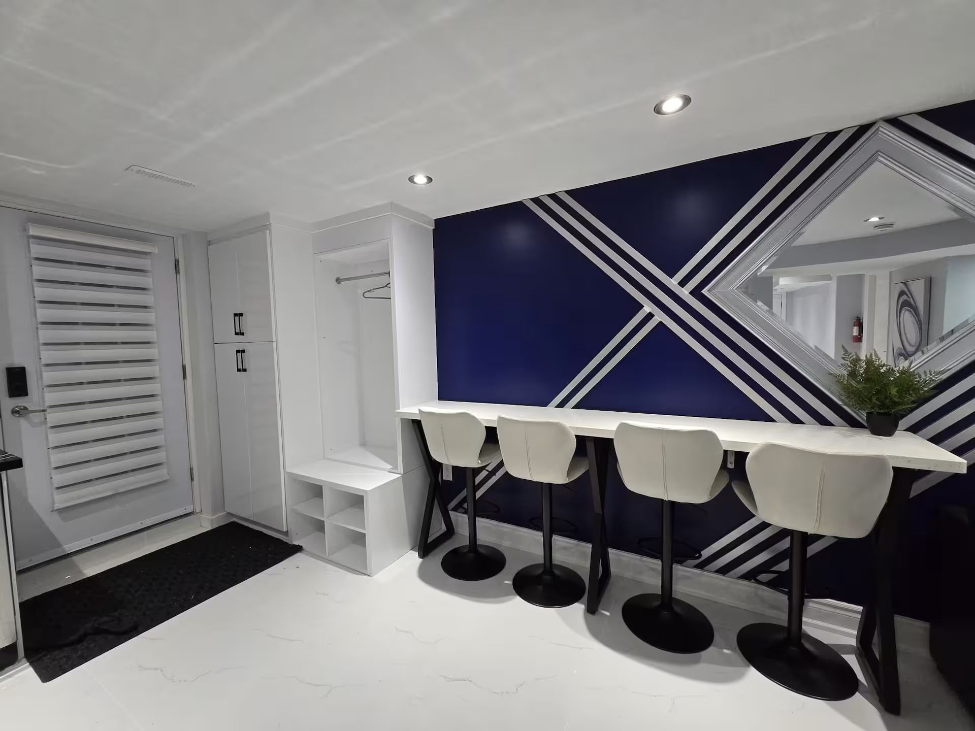 Une cuisine moderne avec des armoires blanches, un comptoir noir et un mur d’accent bleu.