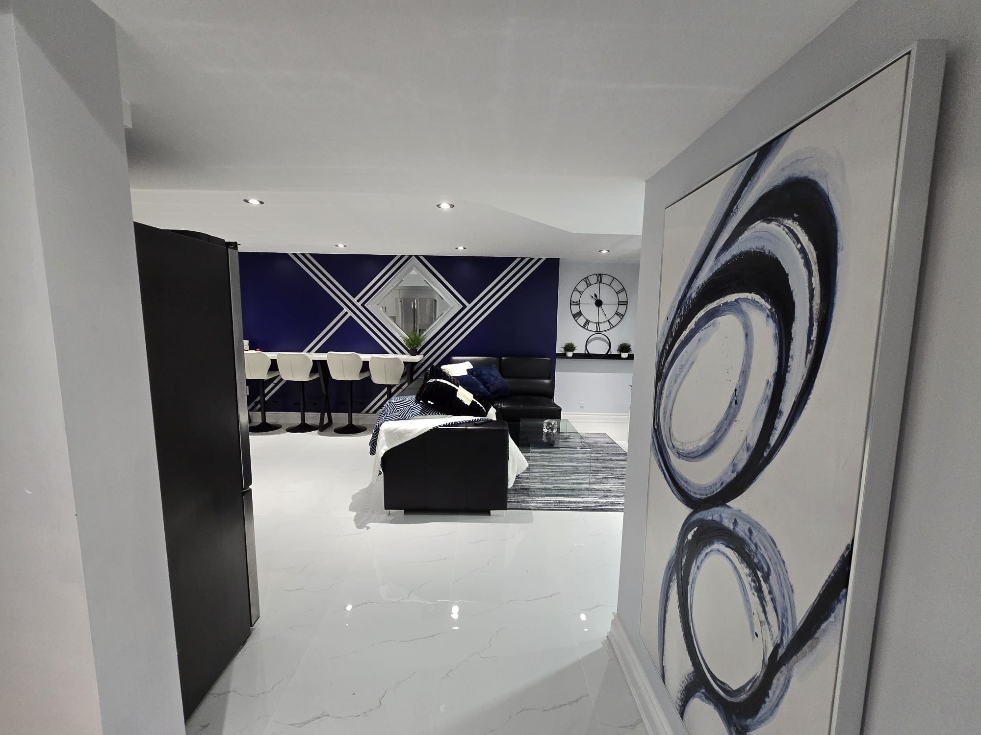 A modern interior with a dining area, a sofa, and a large abstract painting.
