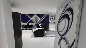 A modern interior with a dining area, a sofa, and a large abstract painting.