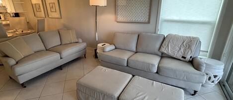 Een woonkamer met twee banken, een salontafel en een vloerlamp.