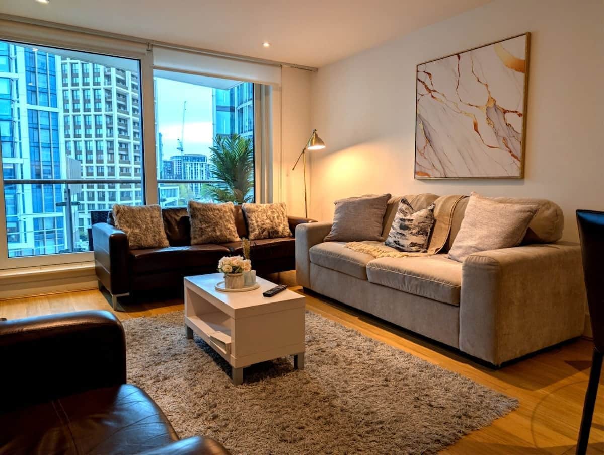 A modern living room with two sofas, a coffee table, and a lamp.