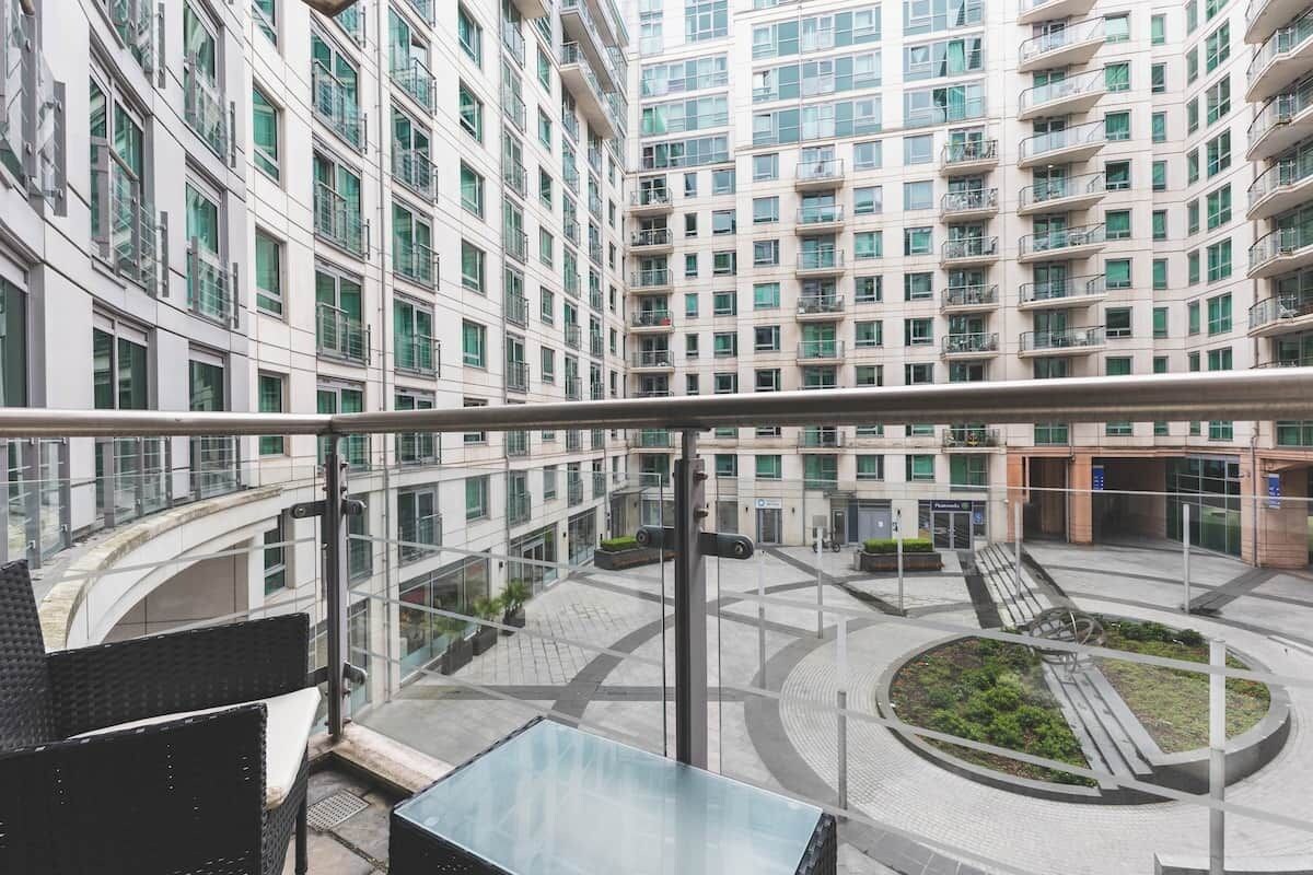A high-rise building with multiple floors, balconies, and a central courtyard with a circular design.