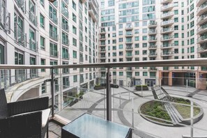 En hög byggnad med flera våningar, balkonger och en central innergård med en cirkelformad design.