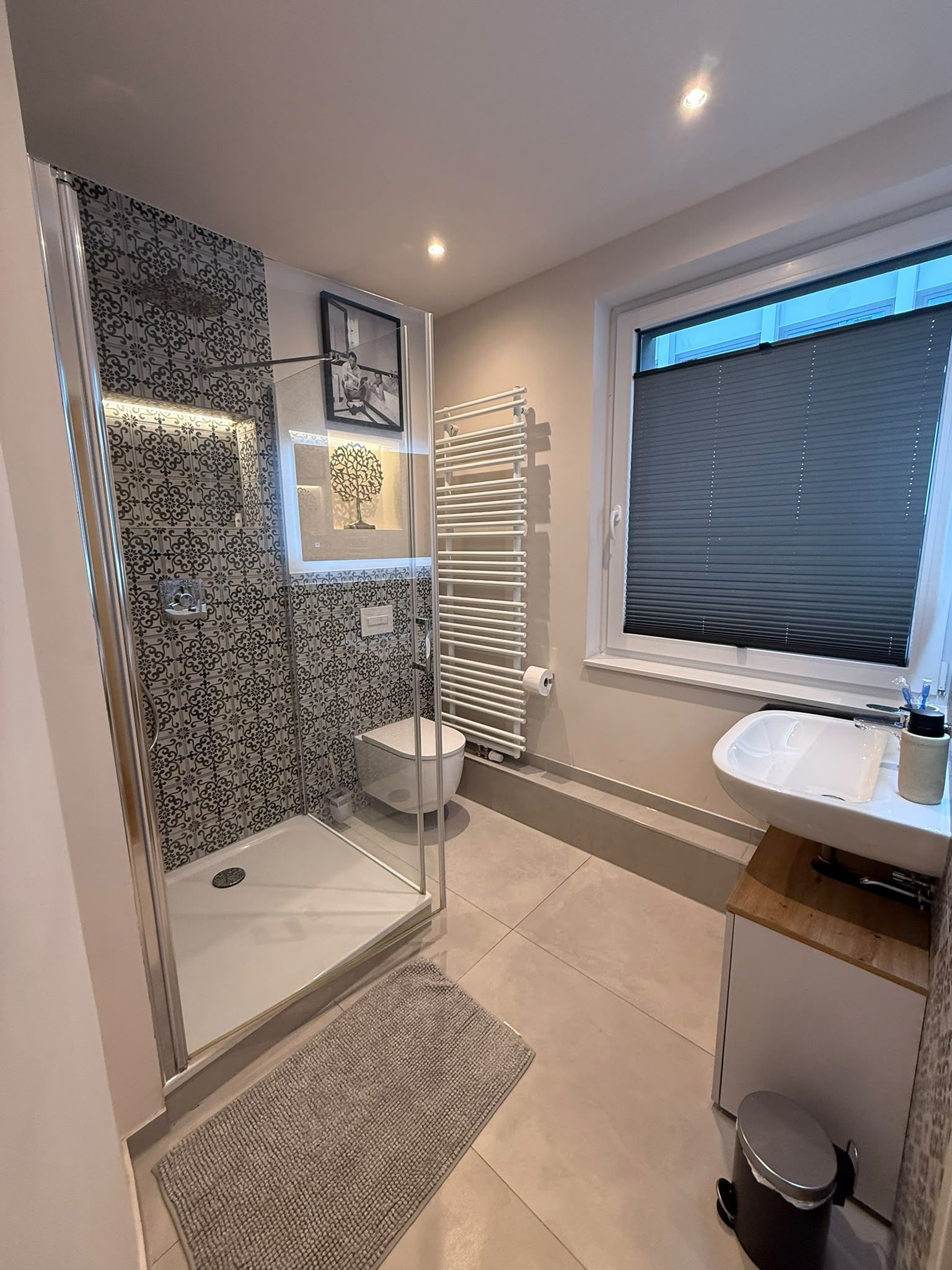 A modern bathroom with a shower, toilet, and sink.