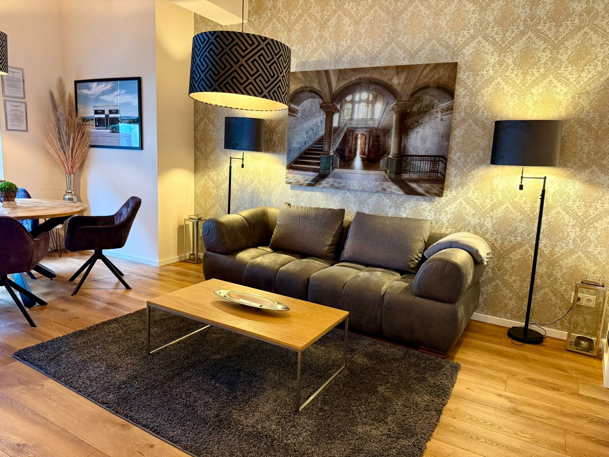 A modern living room with a sofa, coffee table, and two floor lamps.