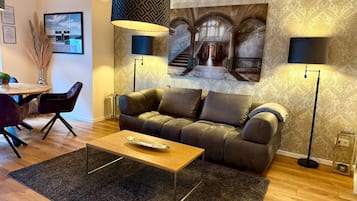 A modern living room with a sofa, coffee table, and two floor lamps.