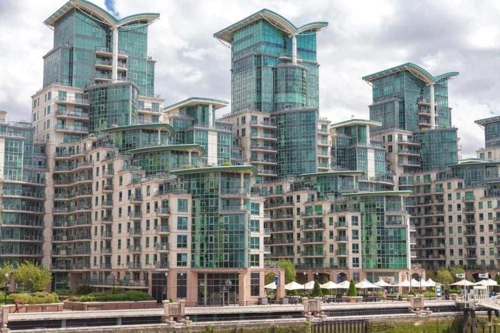 A modern high-rise building with multiple balconies and a glass facade.