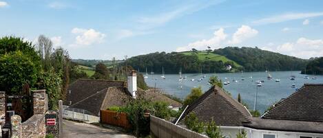 A coastal village with a private property, a stone wall, and a view of boats on the water.