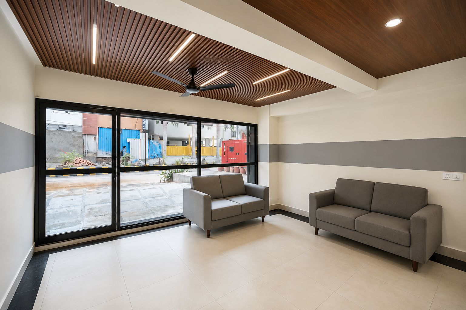 Ein modernes Interieur mit Deckenventilator, großen Fenstern und zwei Sofas.