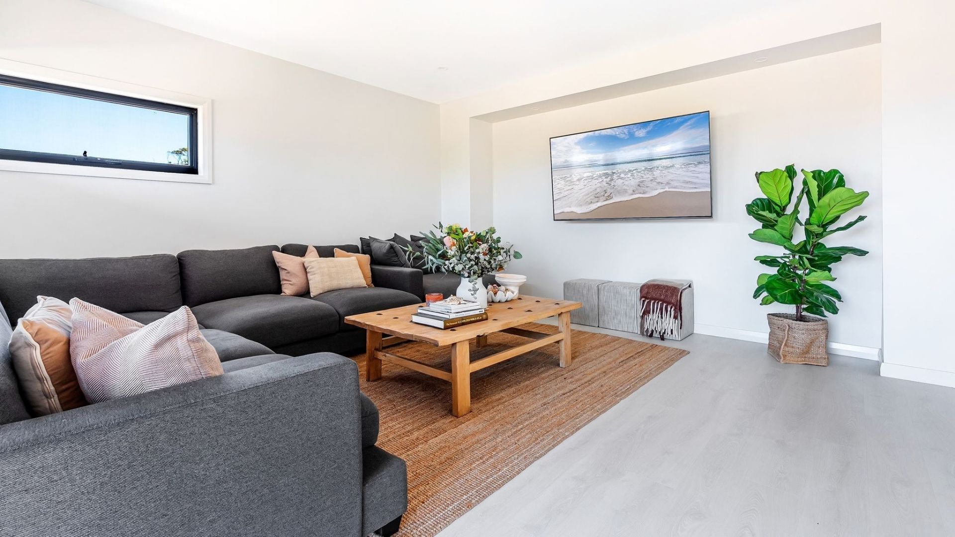 Een moderne woonkamer met een bank, salontafel en een groot raam.