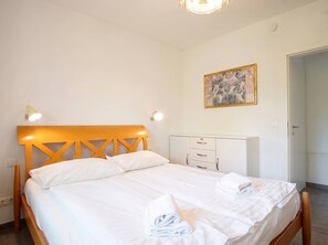A hotel room with a bed, bedside lamps, a wardrobe, and a painting on the wall. - Lichtblick Garden - Near the Lake by WÖRTHWHILE (Seeboden)