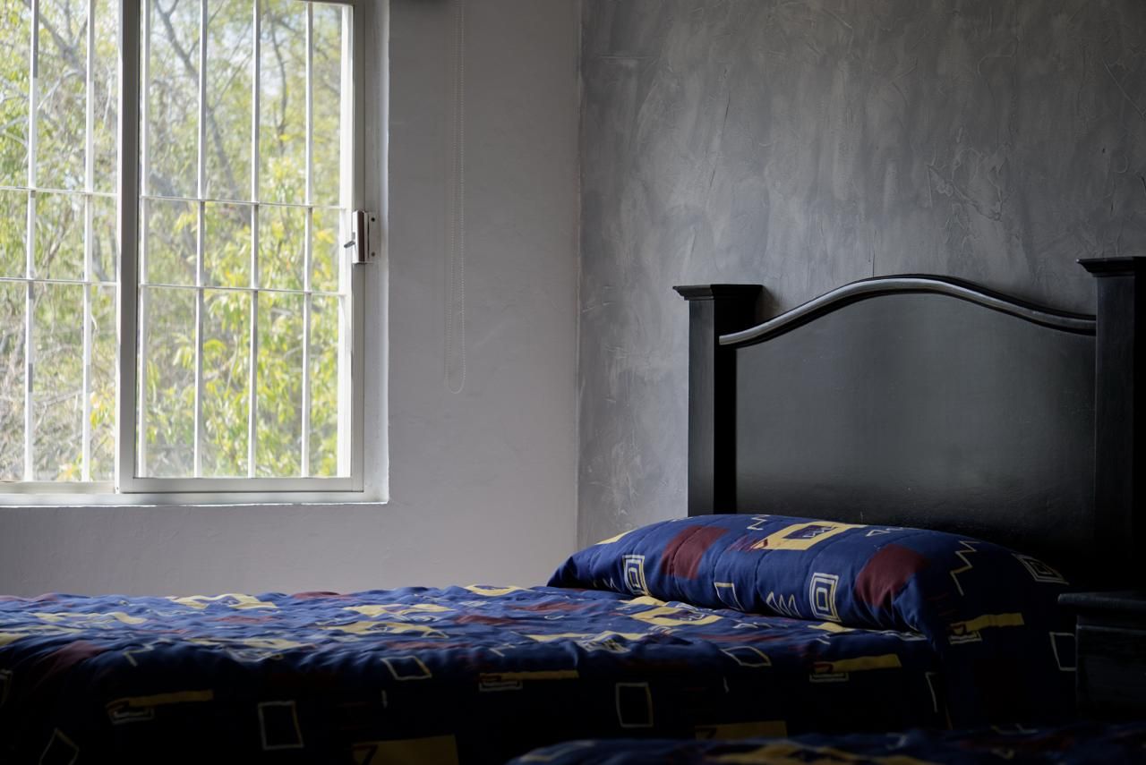 A room with a bed, a window, and a plain wall.
