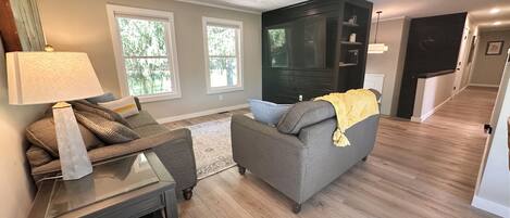 A living room with a sofa, a coffee table, and a TV stand.