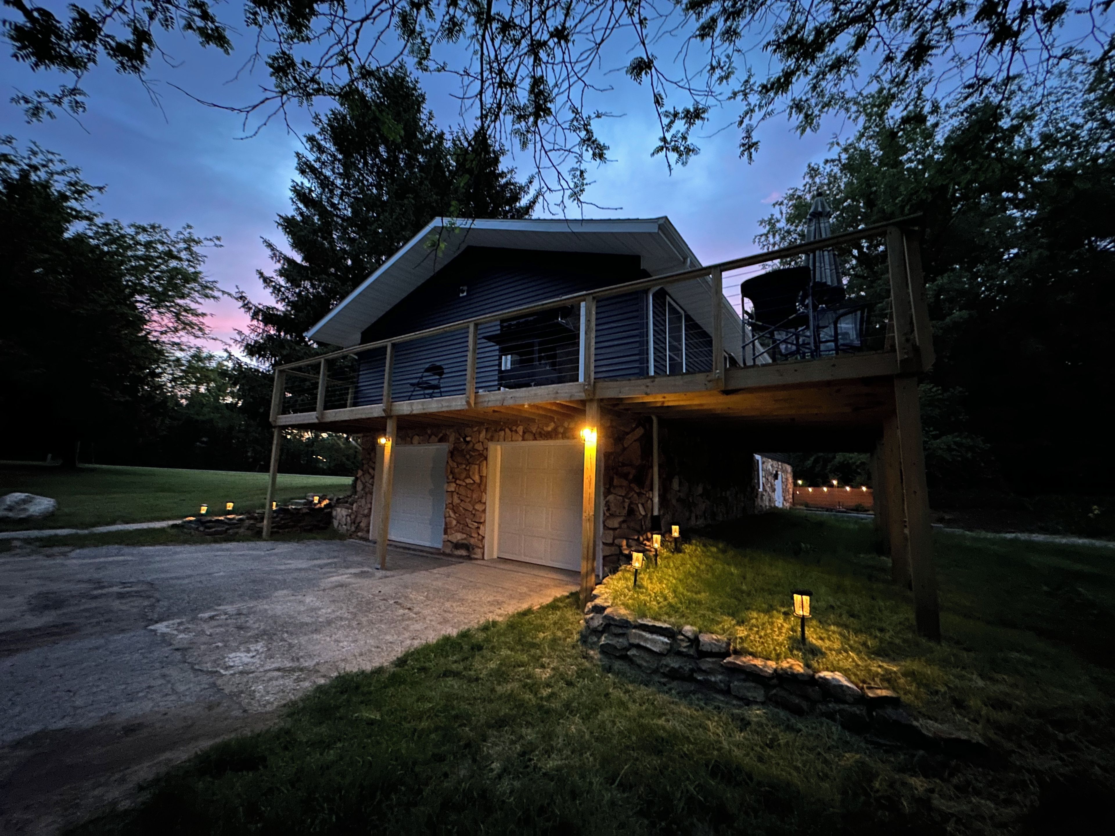A two-story house with a stone foundation, a covered porch, and a garage.