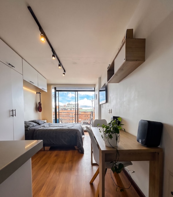 Ein modernes Schlafzimmer mit einem Bett, einer Gitarre und einem großen Fenster.