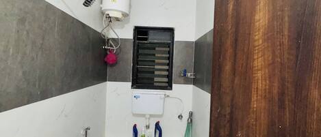 Ein kleines Badezimmer mit Toilette, Dusche, Handtrockner und Fenster.