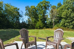 Two Adirondack chairs facing a grassy lawn with trees in the background. - Nolin Lake | Sleeps 10 | Private | Community Pool (Clarkson)