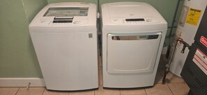 Zwei Waschmaschinen mit Frontlader in einem Waschraum mit grüner Wand und einem Stromzähler.