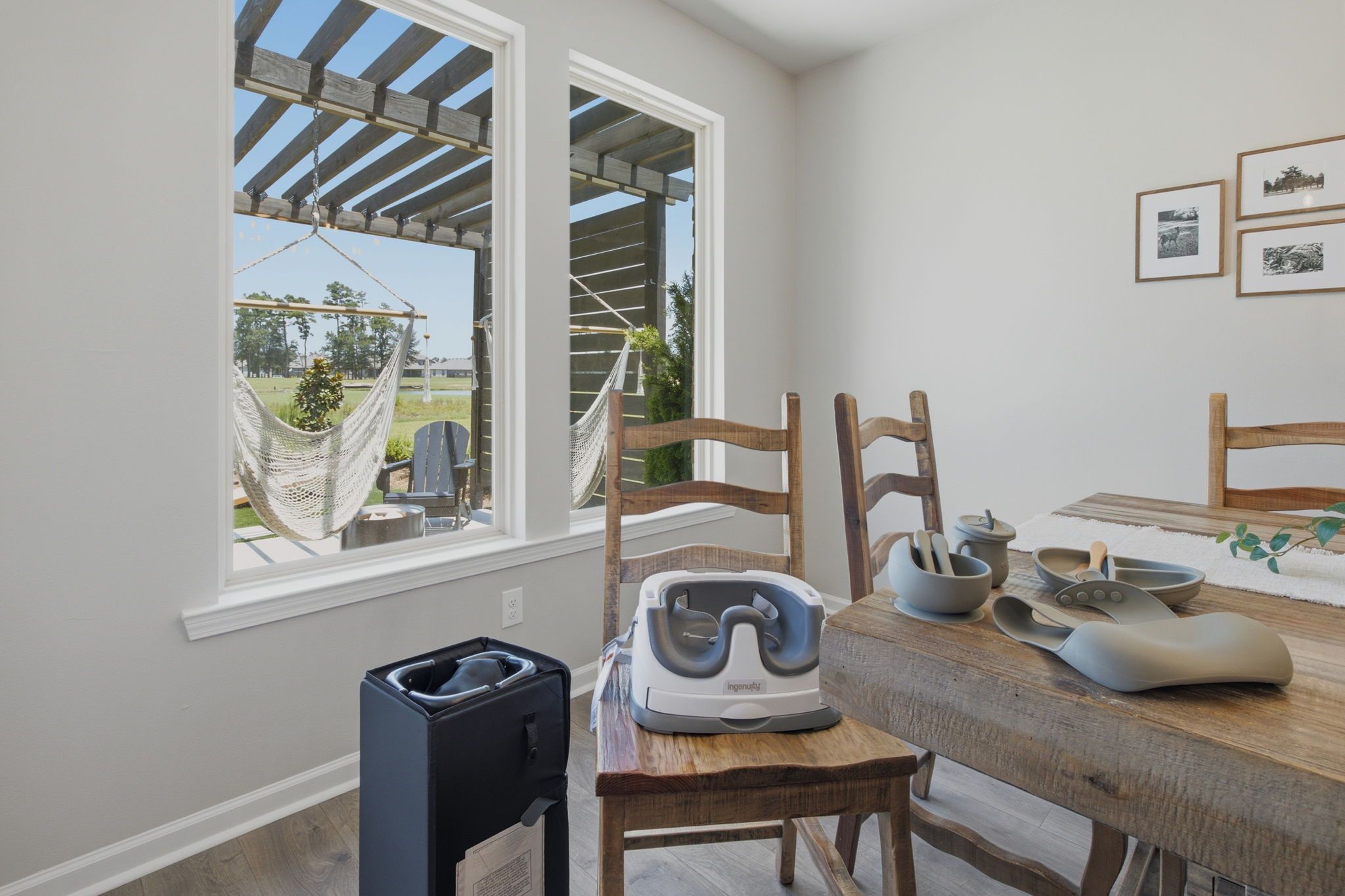 A dining area with a wooden table, chairs, a massage chair, and a view of the outdoors through a window.
