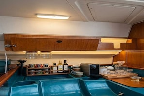 Una cocina compacta con armarios de madera, una encimera y distintos utensilios de cocina.