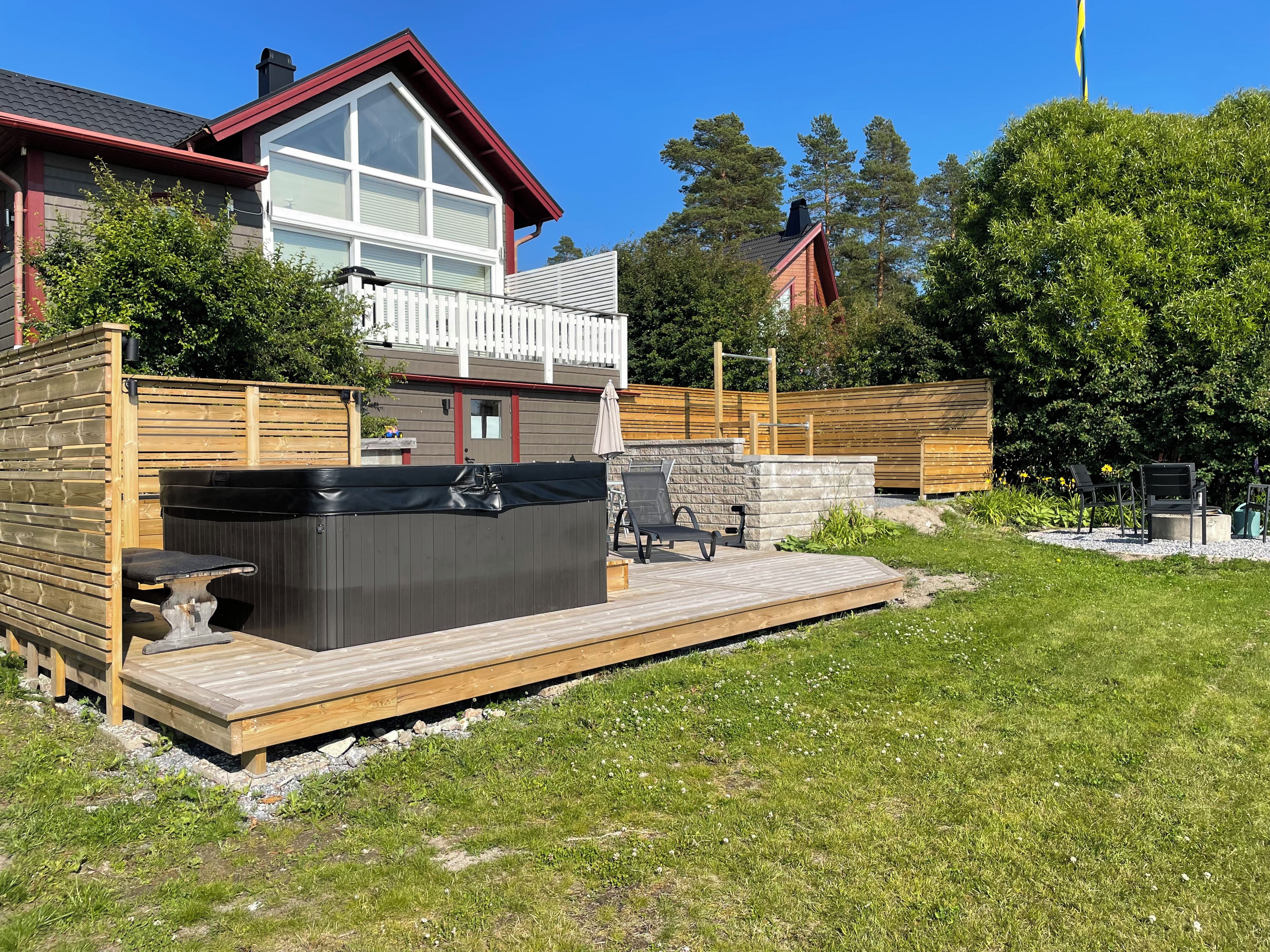 A residential property with a deck, hot tub, and outdoor seating area.