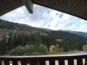Blick auf eine gebirgige Landschaft mit Gebäuden und Bäumen.