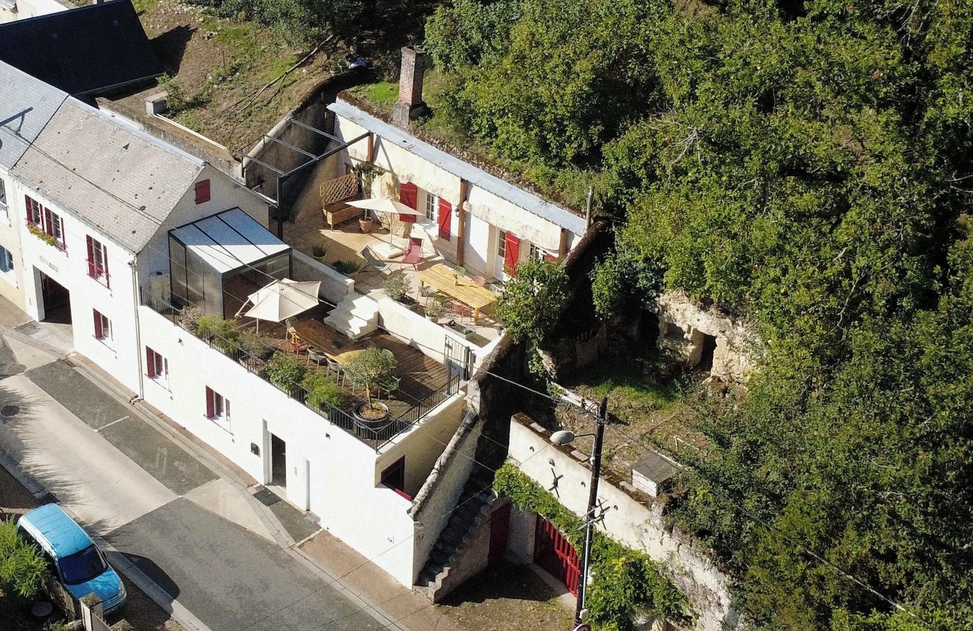A residential area with a white building featuring a balcony and a small patio area.
