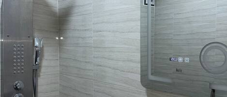 A modern bathroom with a shower, a sink, and a mirror.