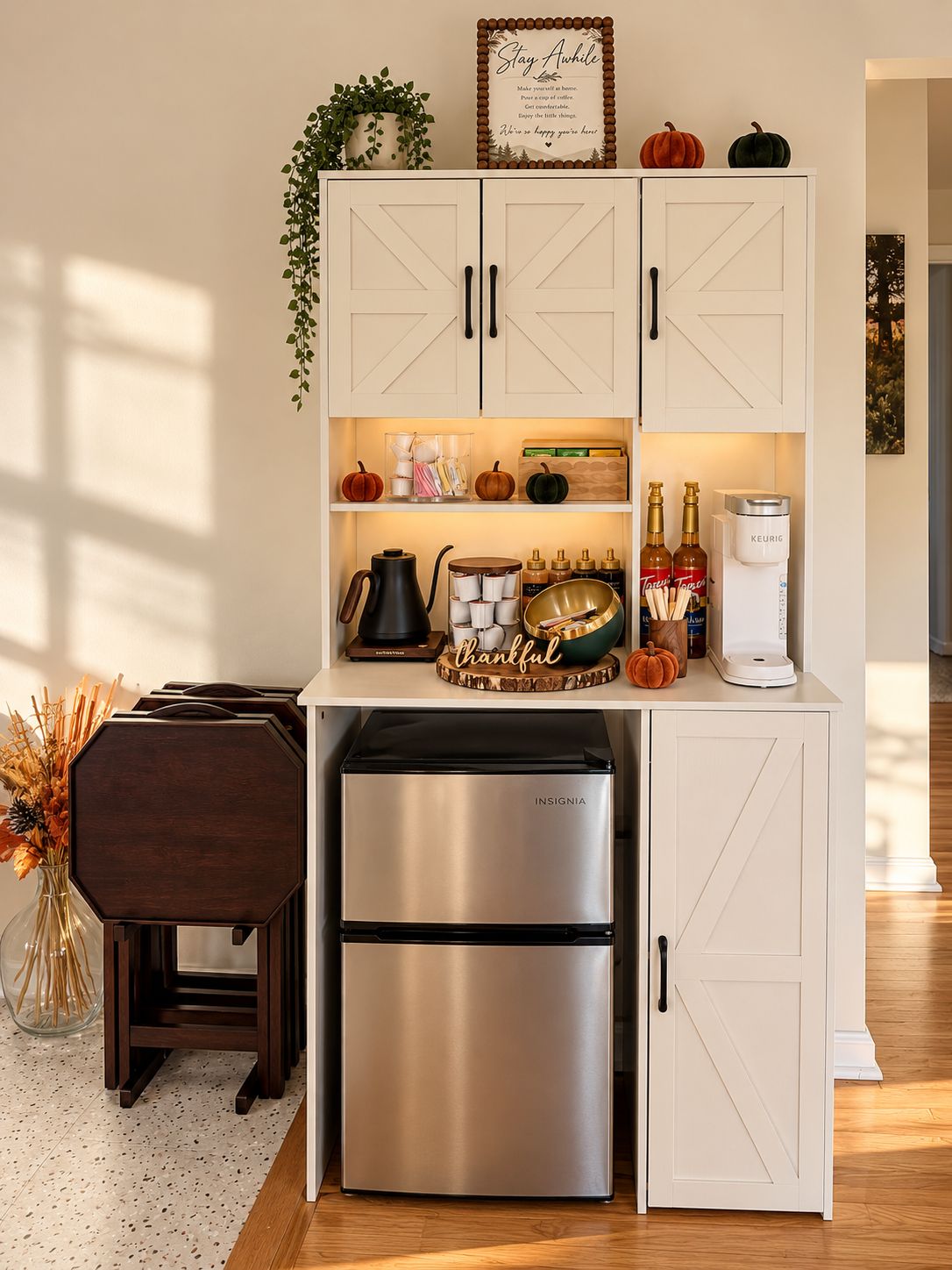 A kitchen with white cabinetry, a stainless steel refrigerator, and a coffee maker.