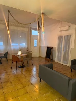 Un interior moderno con comedor, sofás y una escalera.