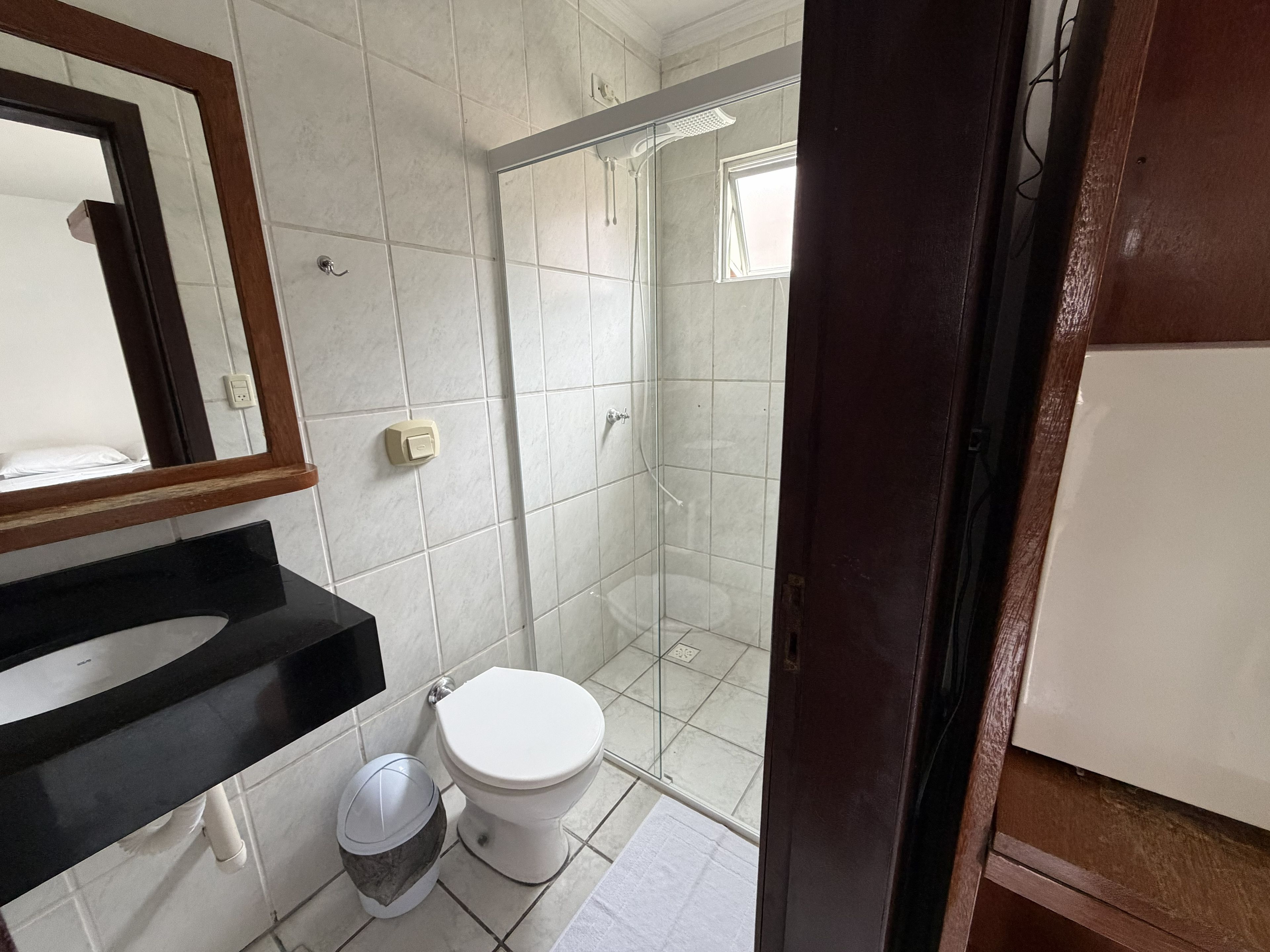 A bathroom with a toilet, sink, and shower.