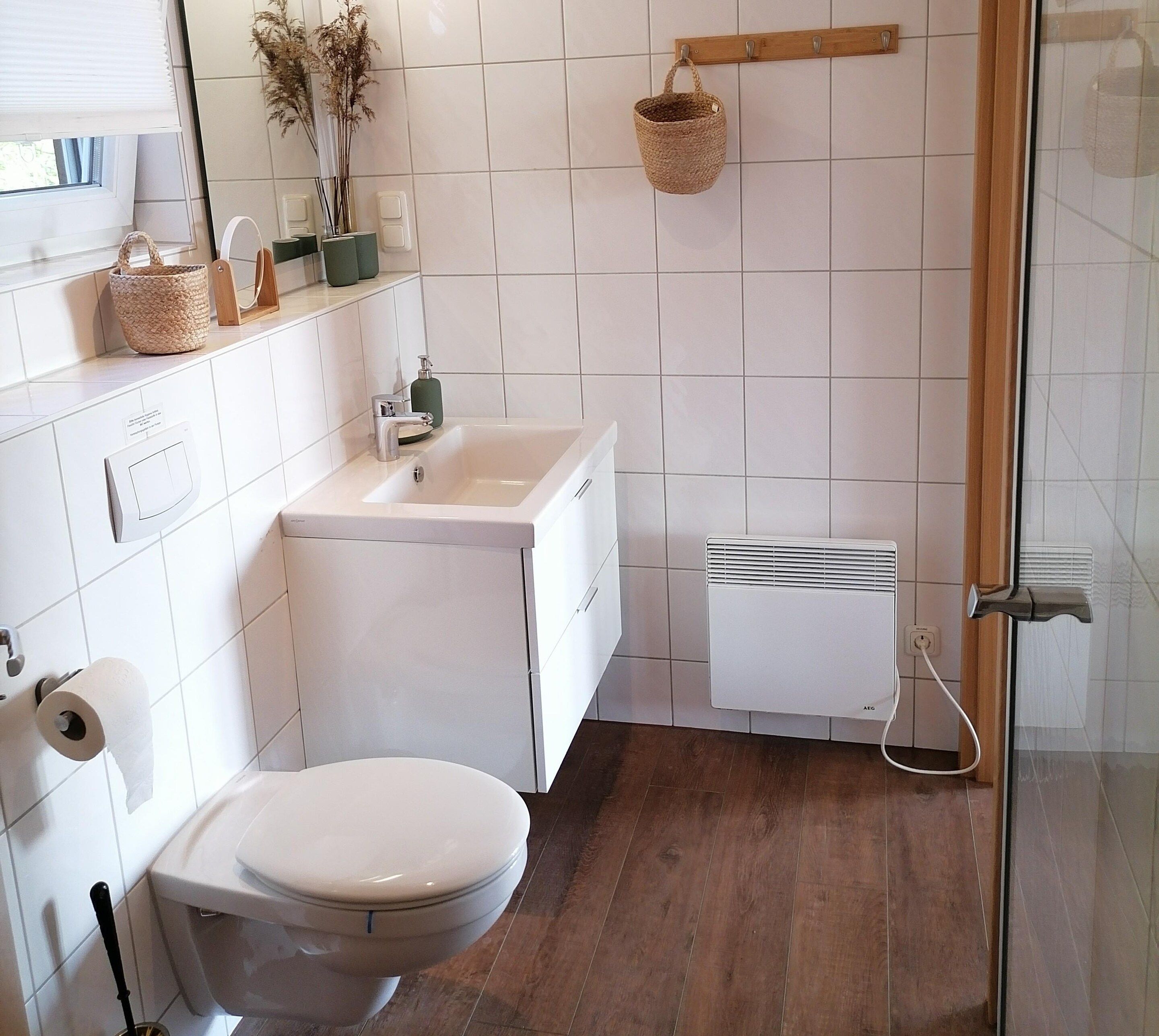 A bathroom with a toilet, sink, and shower.