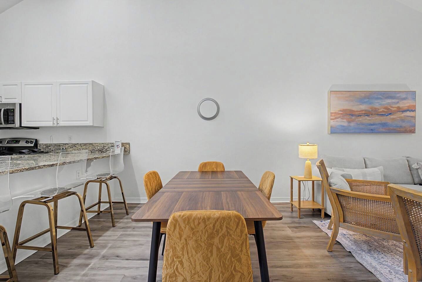 A modern kitchen with white cabinets, a microwave, and a granite countertop.
