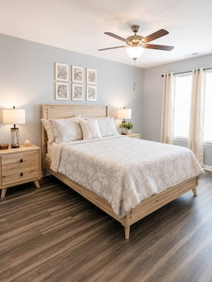 A bedroom with a bed, nightstands, a ceiling fan, and artwork on the wall. - New 3BR Coastal Townhome | Surfside Beach (Surfside Beach)