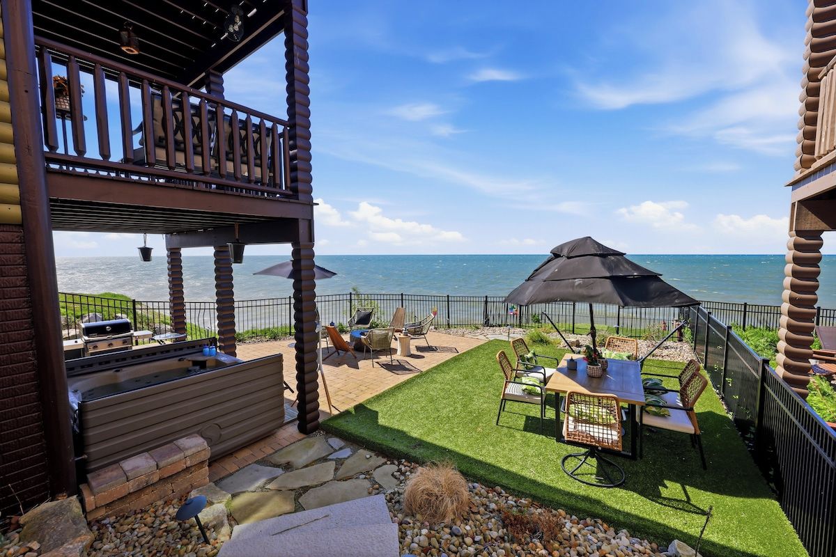 Una terrazza all'aperto con vista sull'oceano, dotata di barbecue e area salotto con ombrelloni.