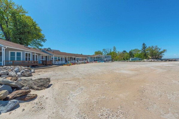 A row of single-story buildings with a dirt ground in front. - Captains Cove: 600 Feet of Shared Private Beach (Vermilion)