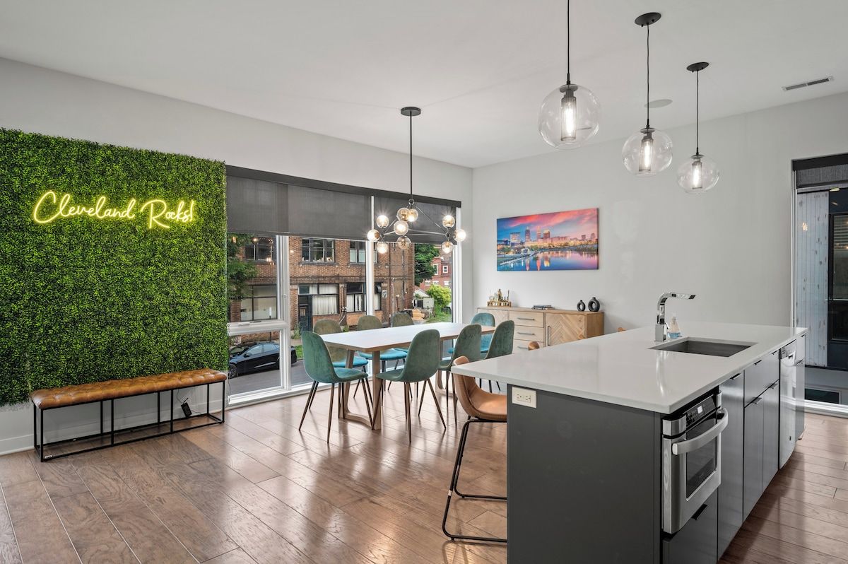 Une cuisine moderne dotée d’un grand îlot central, d’un banc et d’un panneau lumineux au néon.