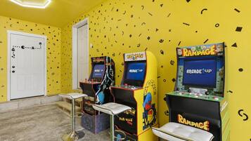 Ein Raum mit Spielautomaten, einer Tür und einer kleinen Sitzecke.