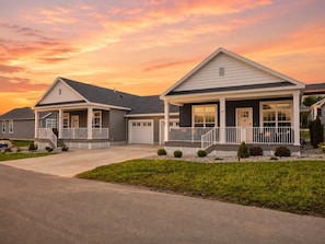 A residential area with two houses, each featuring a front porch, a garage, and a well-maintained lawn. - Baypoint Bungalow-Pool, Beach, and Arcade (Lakeside Marblehead)