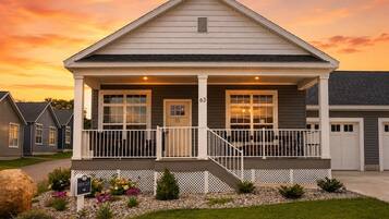 A single-story house with a front porch, a garage, and a well-maintained lawn.