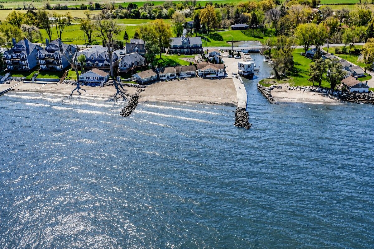 Une zone résidentielle côtière comprenant des maisons, une plage et une voie navigable.