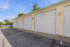 A row of white garage doors with numbers 108 and 109, a paved parking area, and a clear sky. - Lakeside Legend-Hot tub/Pool/Water Views/Billiards (Lakeside Marblehead)
