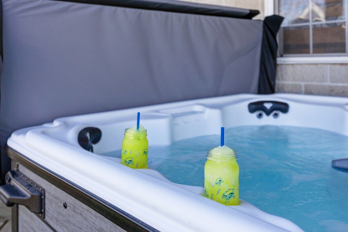 A hot tub with two mason jars filled with a yellow liquid, possibly lemonade, with blue straws.
