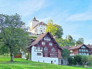 A traditional chalet with a steep roof, a stone base, and a large window. - Panorama House with a View of Three Countries (Sevelen)