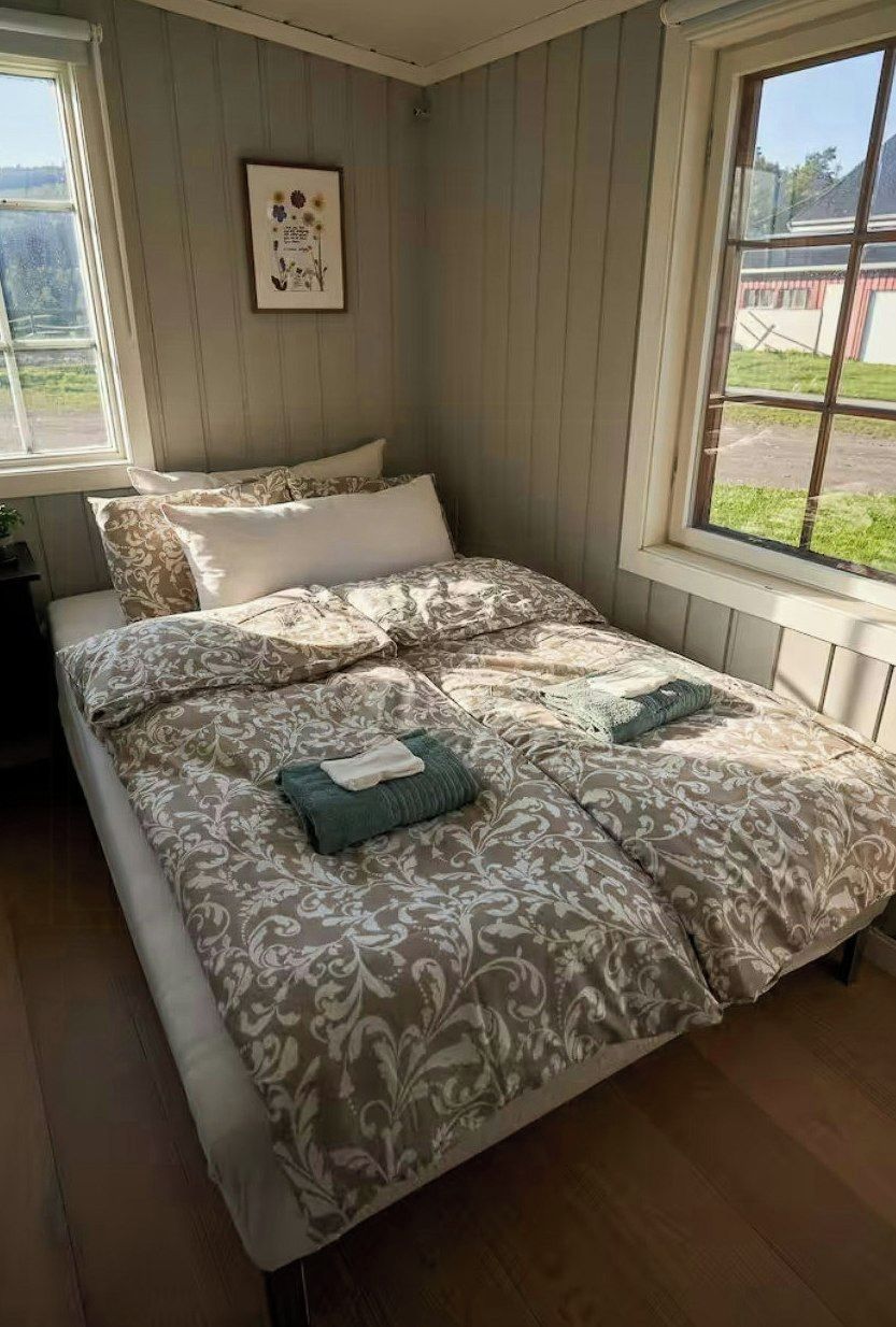 Une chambre à coucher avec un lit, une fenêtre et un tableau accroché au mur.