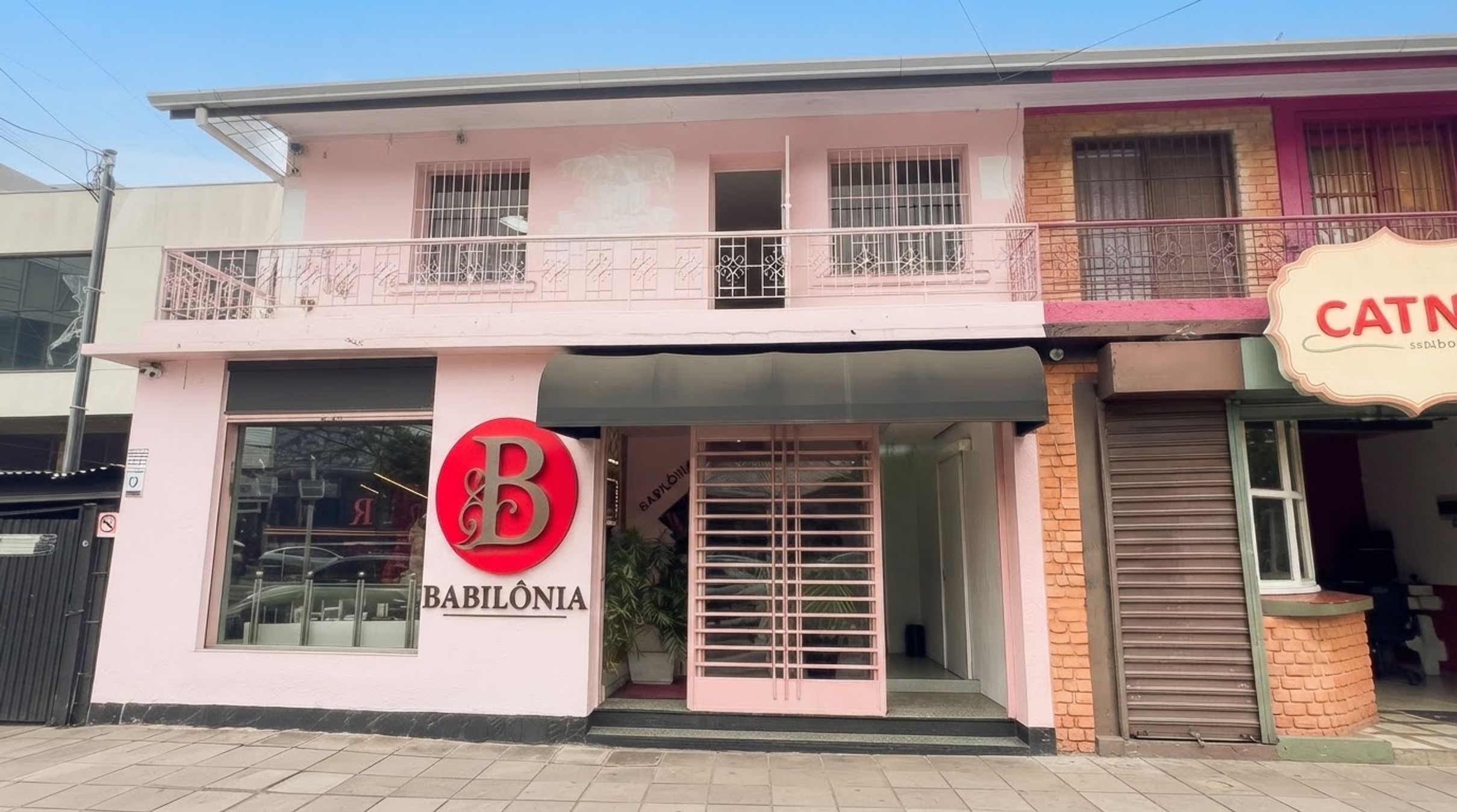 A two-story building with a prominent 'B' logo and 'BABILÔNIA' signage on the ground floor.