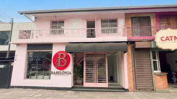 A two-story building with a prominent 'B' logo and 'BABILÔNIA' signage on the ground floor.