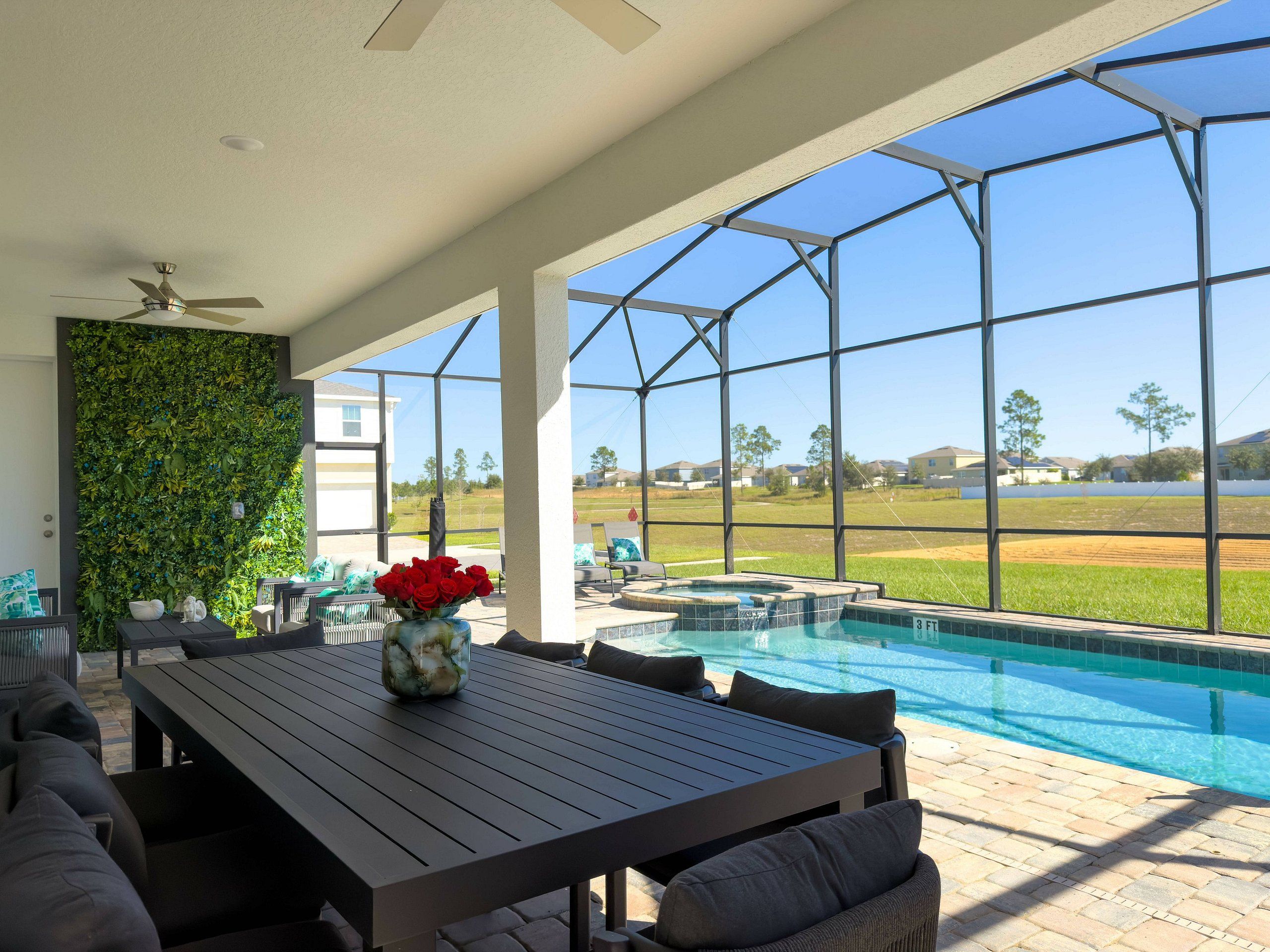 Un patio exterior con piscina, zona de estar y vistas a una zona residencial.