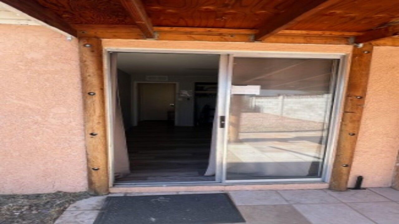 Une entrée d ’immeuble dotée d’une porte coulissante en verre qui donne sur un espace intérieur.